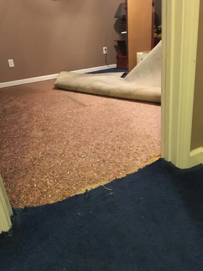 Carpet pad removal revealing water damage during Water Mitigation Services in North Platte
